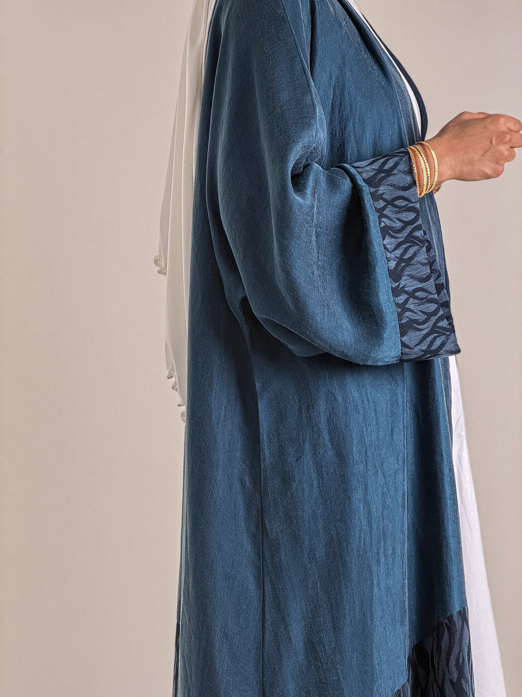 Détail du tissu et de la manche d'une abaya Qamarayn bleue